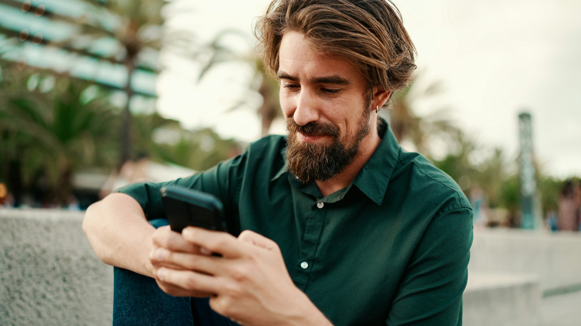 Closeup of a young hipster man using a mobile phone